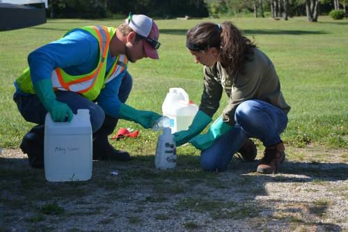 Two members of our staff prepare herbicide.
